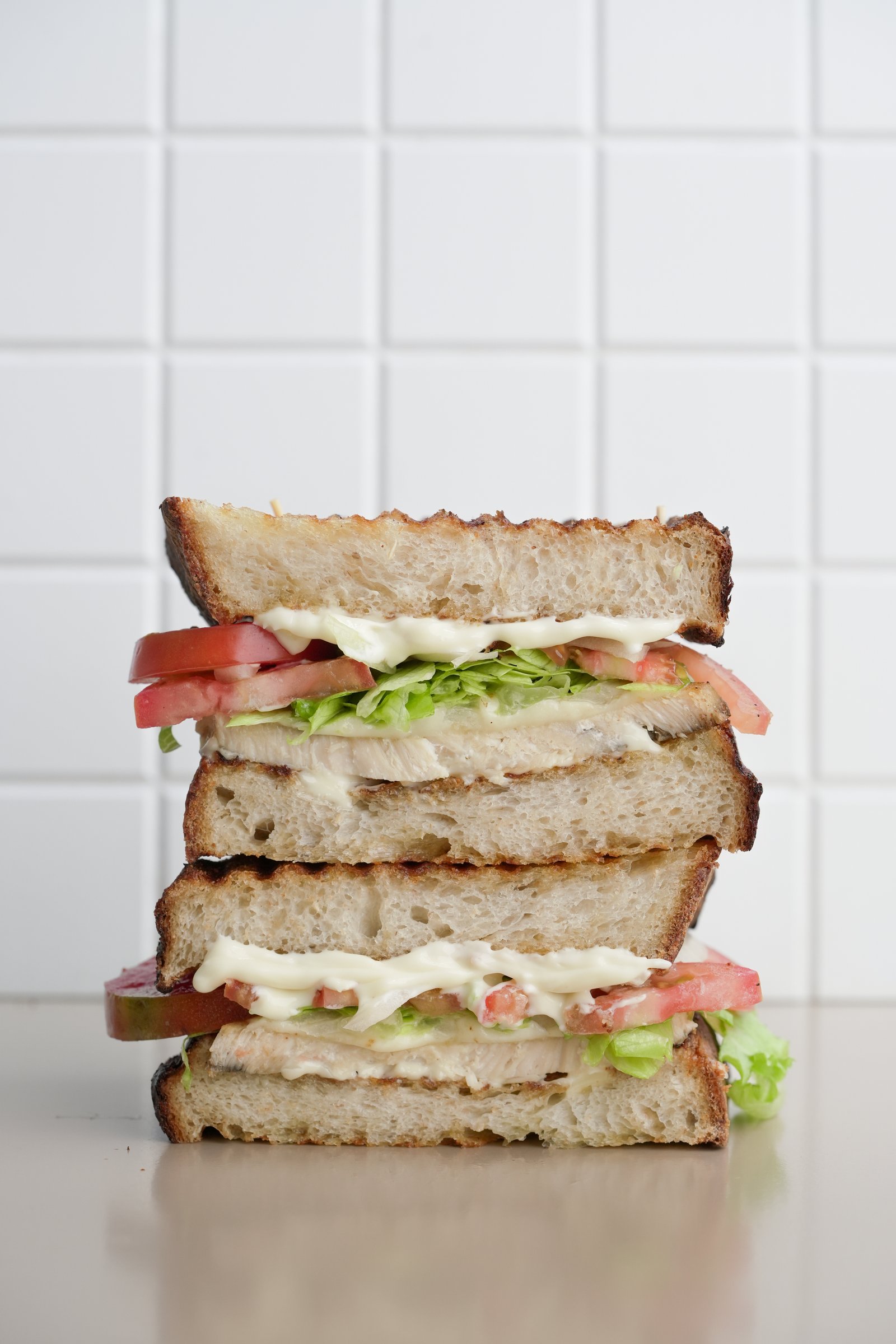 Chicken Sandwich — sourdough, chicken breast, mayonnaise, red onion, iceberg lettuce, emmental cheese, tomato