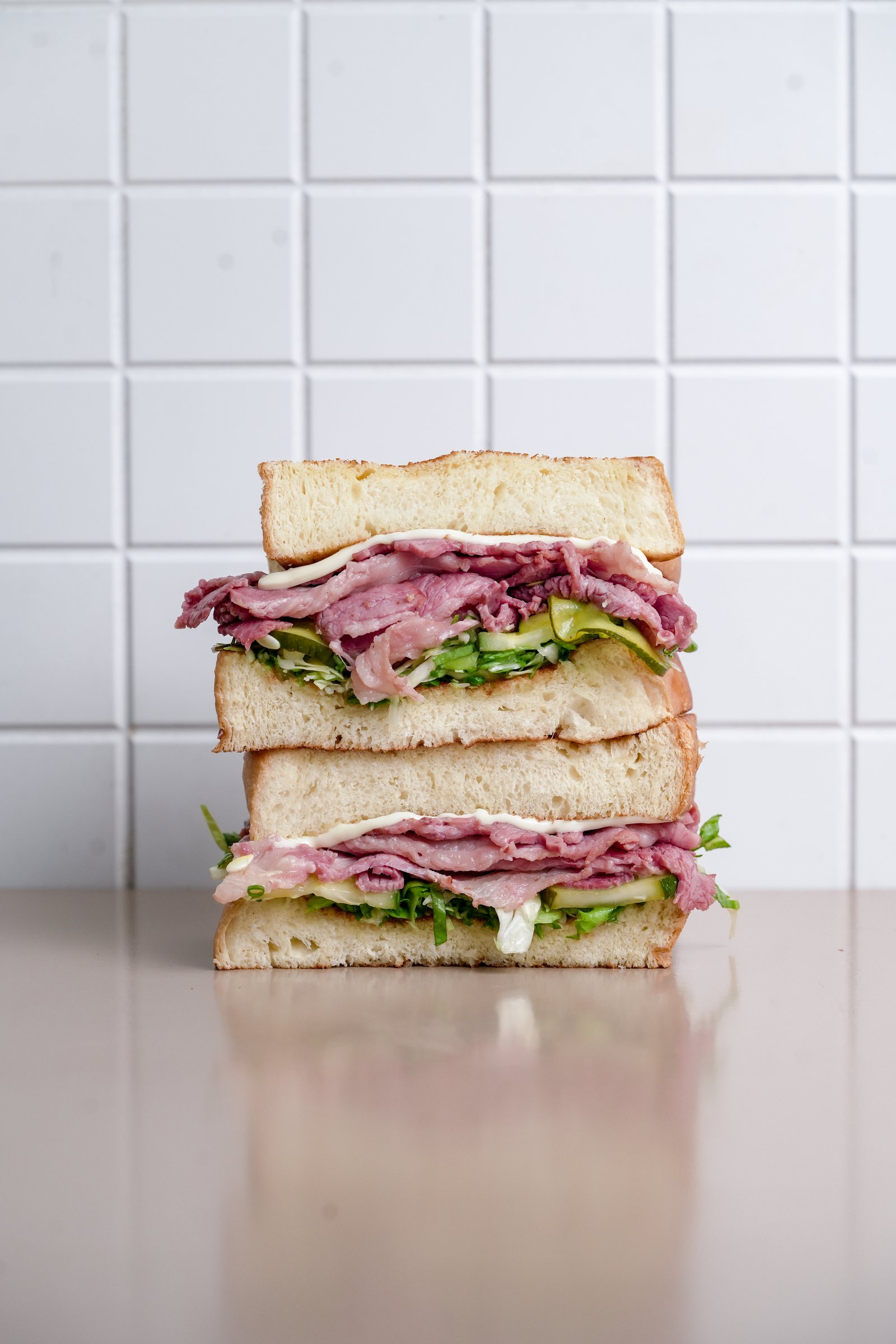 Pastrami Sandwich — brioche, house-smoked beef pastrami, white cabbage, iceberg, mayo, spring onion, cucumber pickle