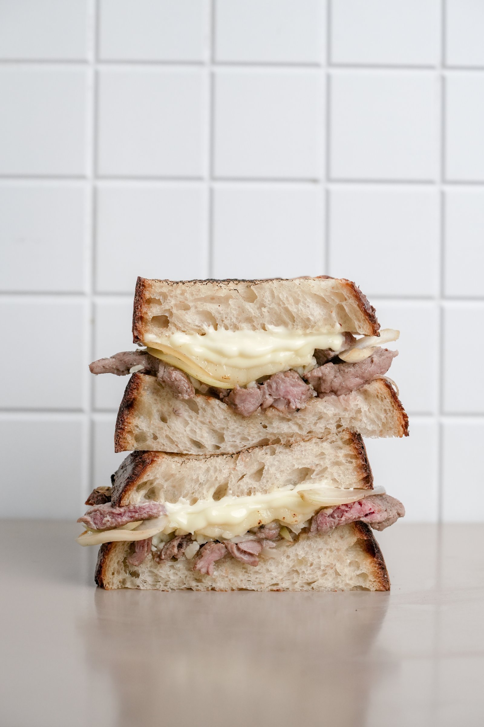 Philly Cheesesteak — sourdough, sliced beef, sautéed onion, capsicum, melted cheese